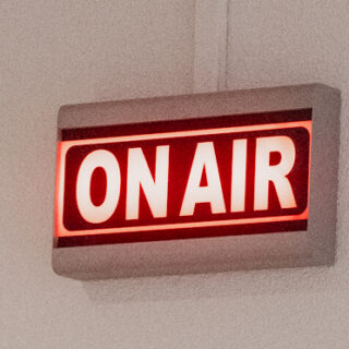 Een bord met daarop On Air